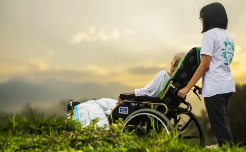 車椅子に乗った老人と介護者